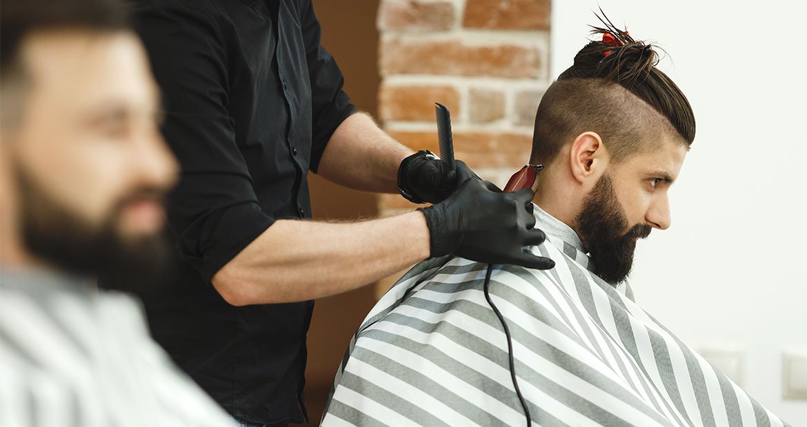 Barbeiro realiza o corte undercut com cabelo longo em seu cliente com cabelo grande masculino